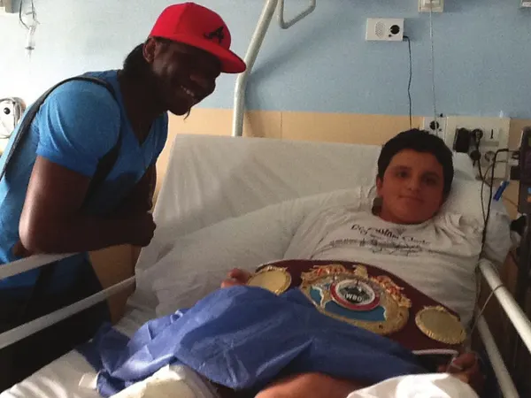 Hassan N'Dam au chevet d'un enfant hospitalisé, ceinture posée sur le lit